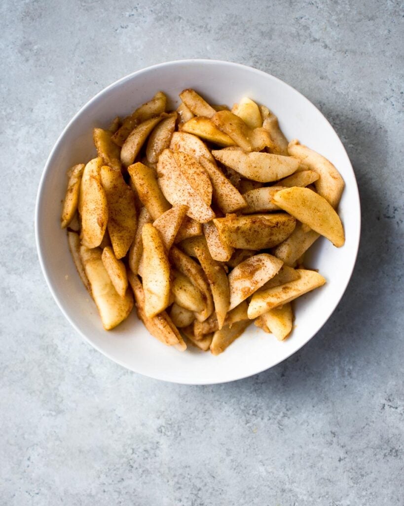 sauteed apples in a ceramic bowl on concrete