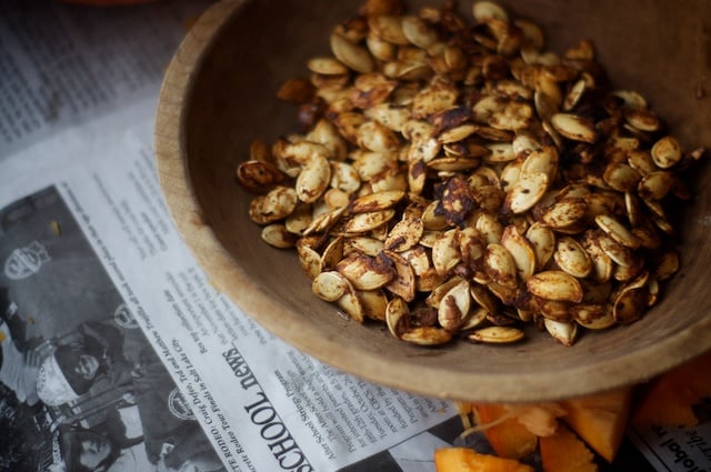 Freshly toasted pumpkin seeds sitting on newspaper.