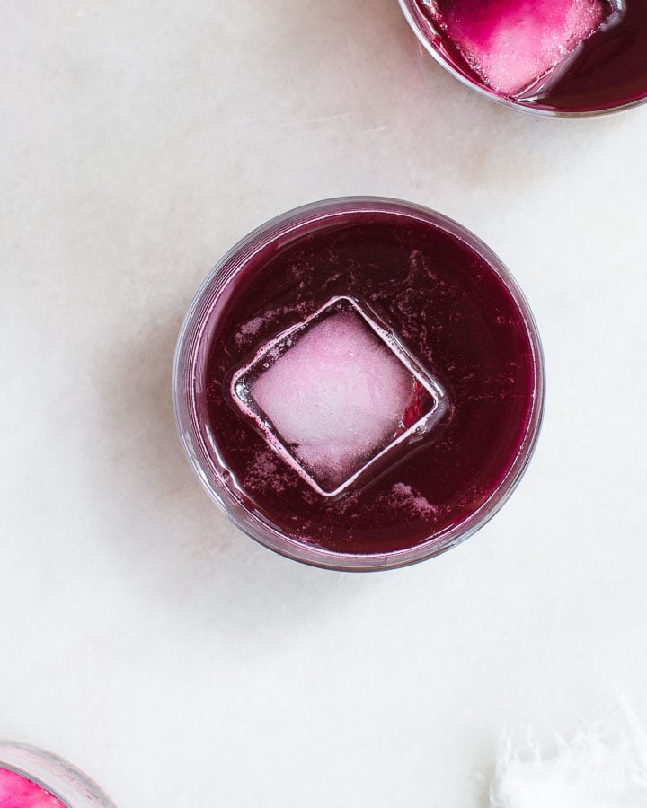 Three glasses of beet kvass served with ice.