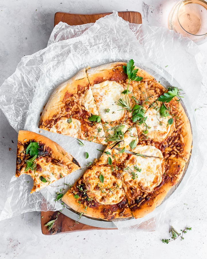 Sourdough einkorn pizza garnished with fresh herbs