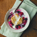 summer berry cobbler on white dish on green napkin