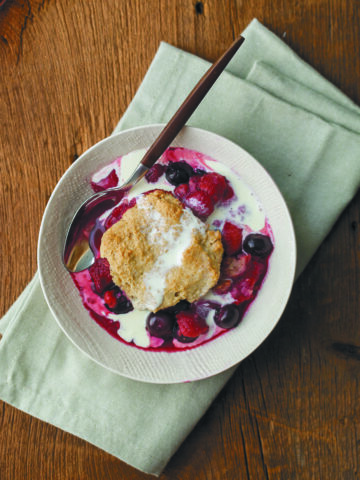 summer berry cobbler on white dish on green napkin