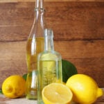 limoncello in glass bottle next to sliced lemons