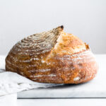 sourdough bread on a white background with flower in a container