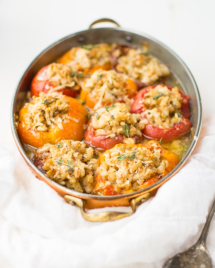 Heirloom tomatoes stuffed with white beans in a copper dish.
