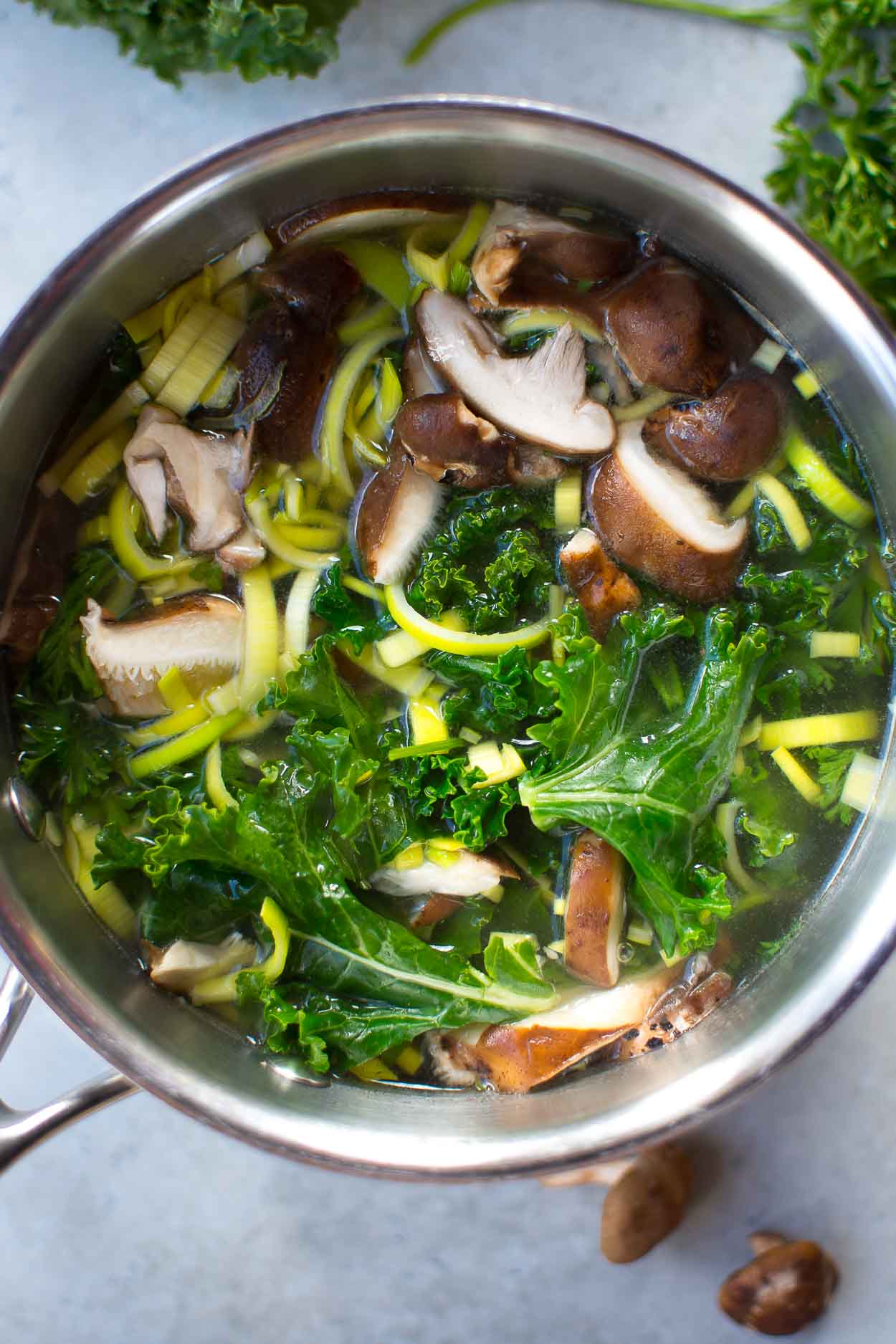 Shiitake mushrooms, kale and leeks in a saucepan