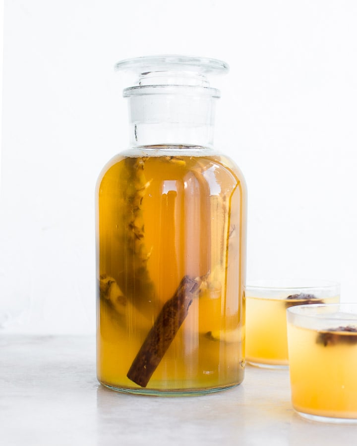 Tepache de Piña fermenting in a large  glass jar with cinnamon and star anise.