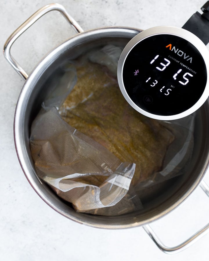 Vacuum-sealed flank steak in a water bath heated by sous vide immersion circulator