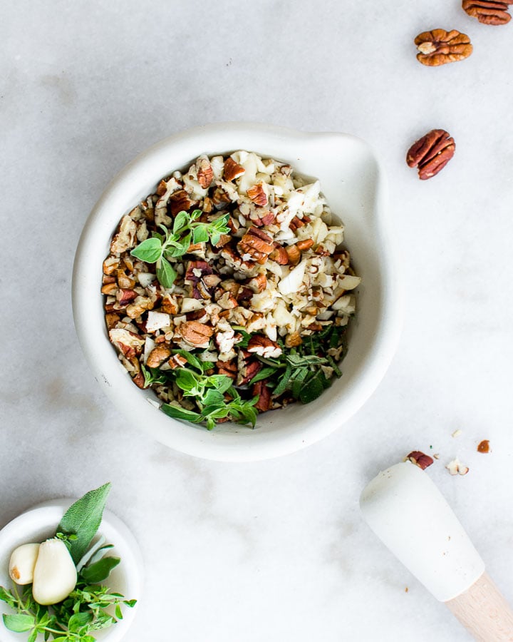 Pecans, marjoram and garlic in a bowl.