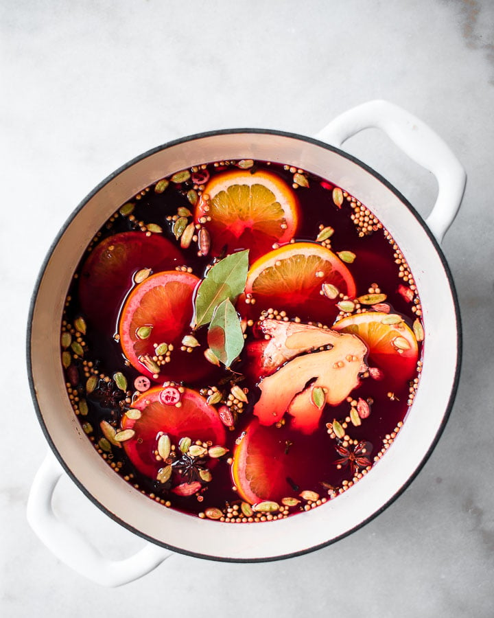 Pot filled with cranberry cider, oranges, ginger and other spices.