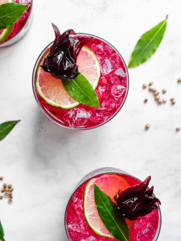 hibiscus elixer in a cup with ice and lime