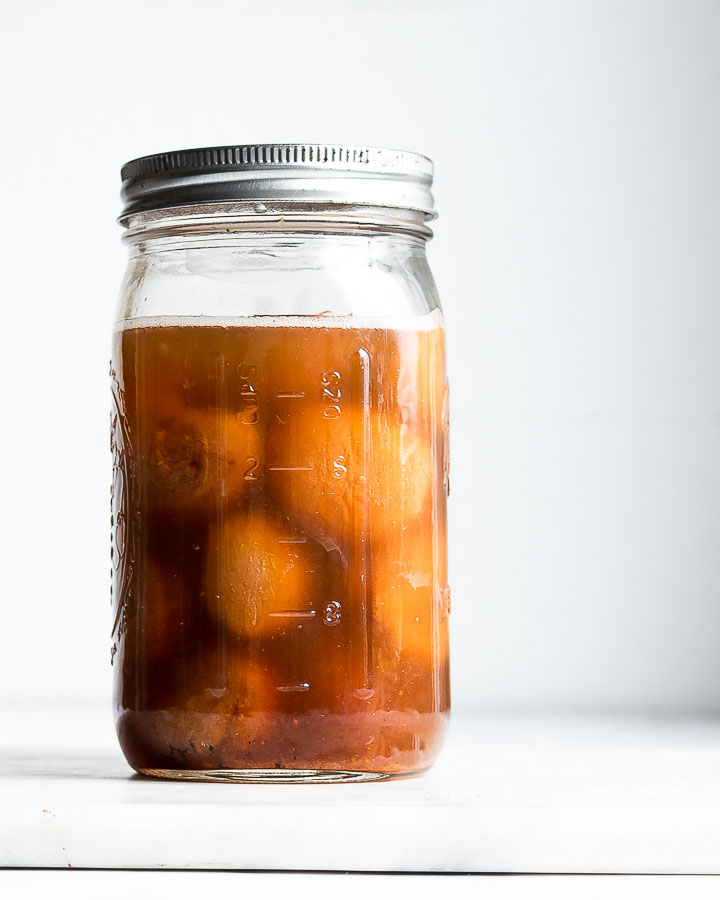 Mason jar containing dried apricots and water, cultivated for wild yeast.