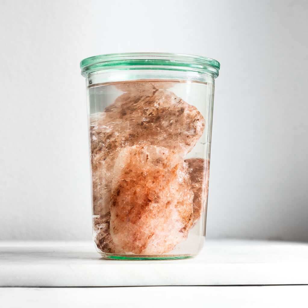 Unrefined salt crystals in a jar for making sole water.
