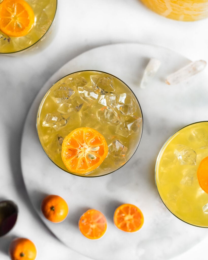 Calamansi juice on a marble surface garnished by sliced calamansi fruit.