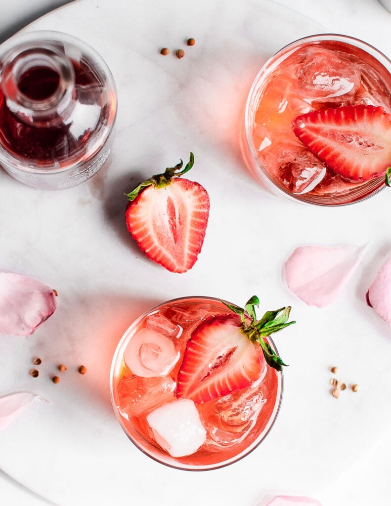 strawberry rosé smash shot from above garnished with strawberries and rose petals