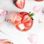 Strawberry smash in glass cup, garnished with ice and sliced strawberry