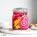Chioggia beets and fresh ginger in a Fido jar on a marble tray ready for fermentation.
