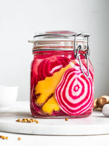 Chioggia beets and fresh ginger in a Fido jar on a marble tray ready for fermentation.
