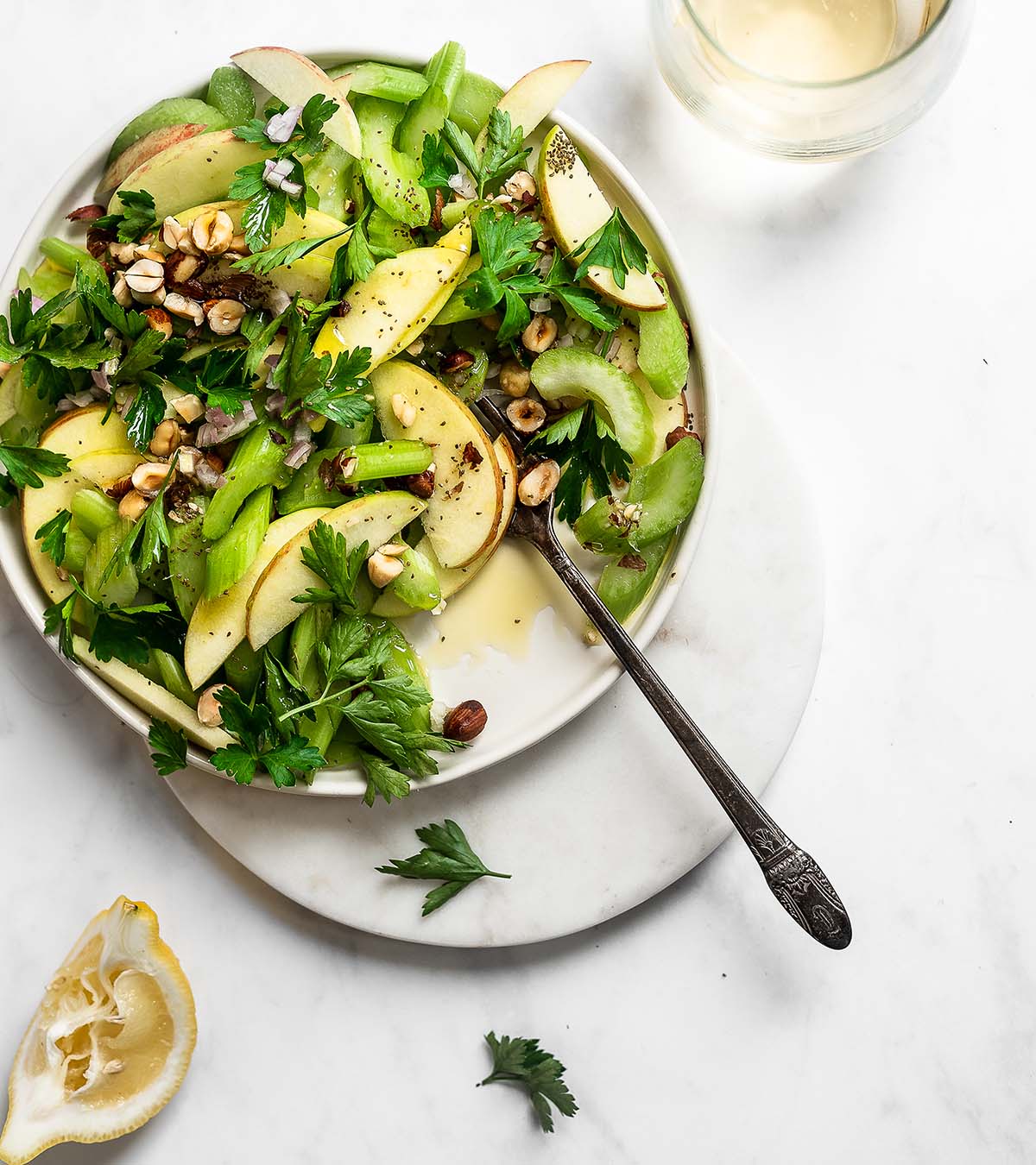 Celery salad with apples, shallots, parsley and walnuts on a flat plate