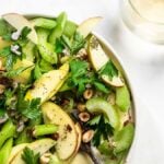 Celery salad with apples, shallots, parsley and walnuts on a flat plate