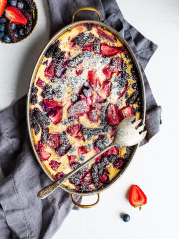 Flaugnarde with blueberries, strawberries, raspberries and mulberries, dusted with powdered sugar