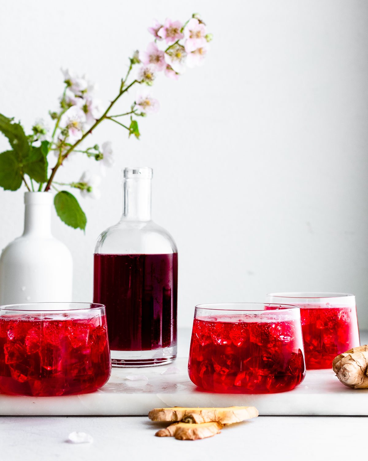 Blackberry switchel garnished with blackberries and blackberry flowers