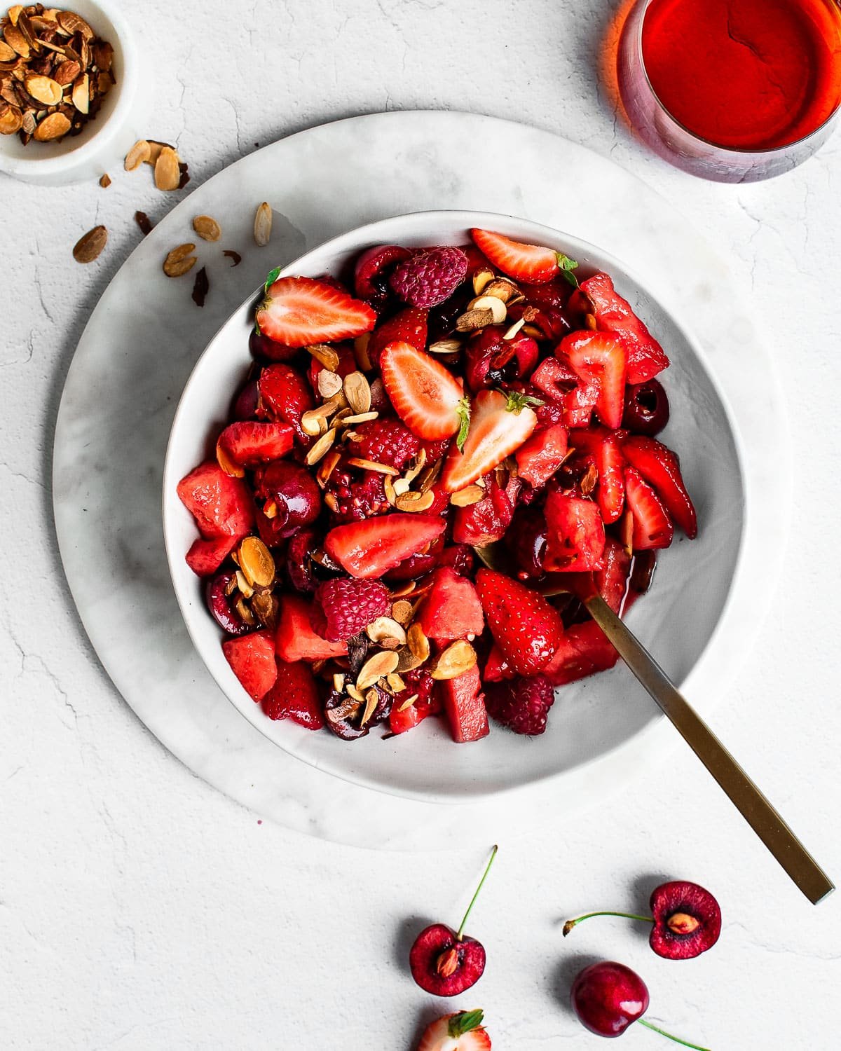 Red fruit salad with strawberries, raspberries, cherries and watermelon in a white bowl