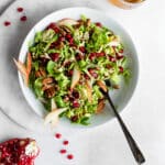 Brussels Sprout Slaw in White Bowl Garnished with Pomegranates