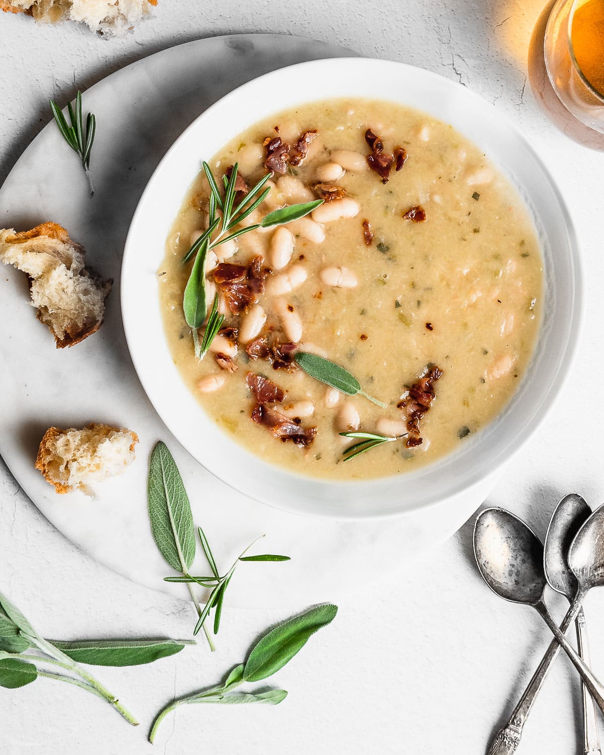 White bean soup garnished with pancetta, sage and rosemary