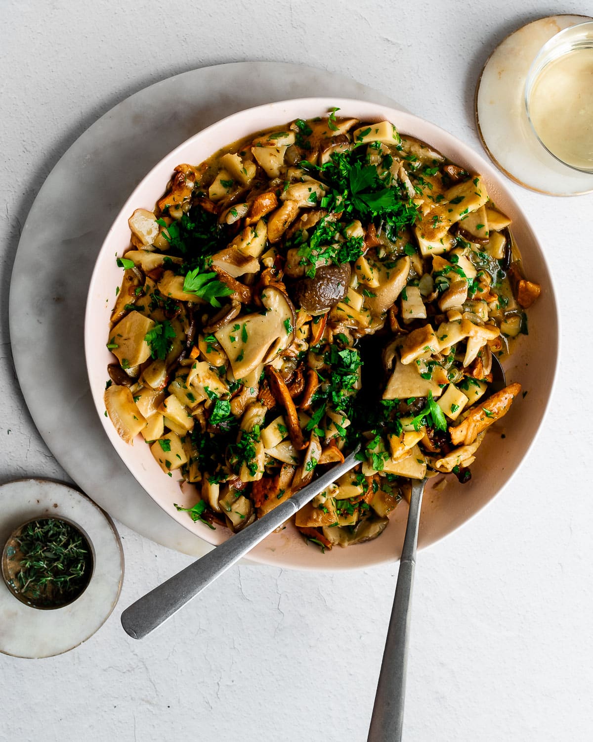 Braised wild mushrooms in a bowl, garnished with parsley.