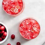 Cranberry kvass served with ice, garnished with sliced cranberries