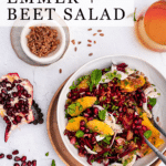 Emmer and beet salad garnished with fennel, oranges and mint in a white bowl