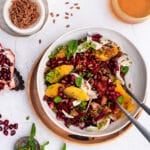 Emmer and beet salad garnished with fennel, oranges and mint in a white bowl