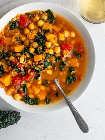 winter minstrone in a white bowl on a white surface