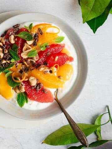 Winter citrus bowl garnished with mint, hazelnuts and cacao