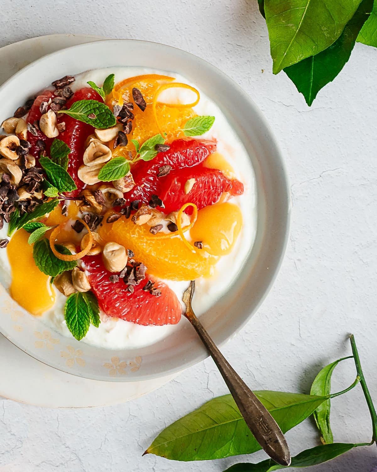 Winter citrus bowl garnished with mint, hazelnuts and cacao