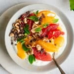 Winter citrus bowl garnished with mint, hazelnuts and cacao