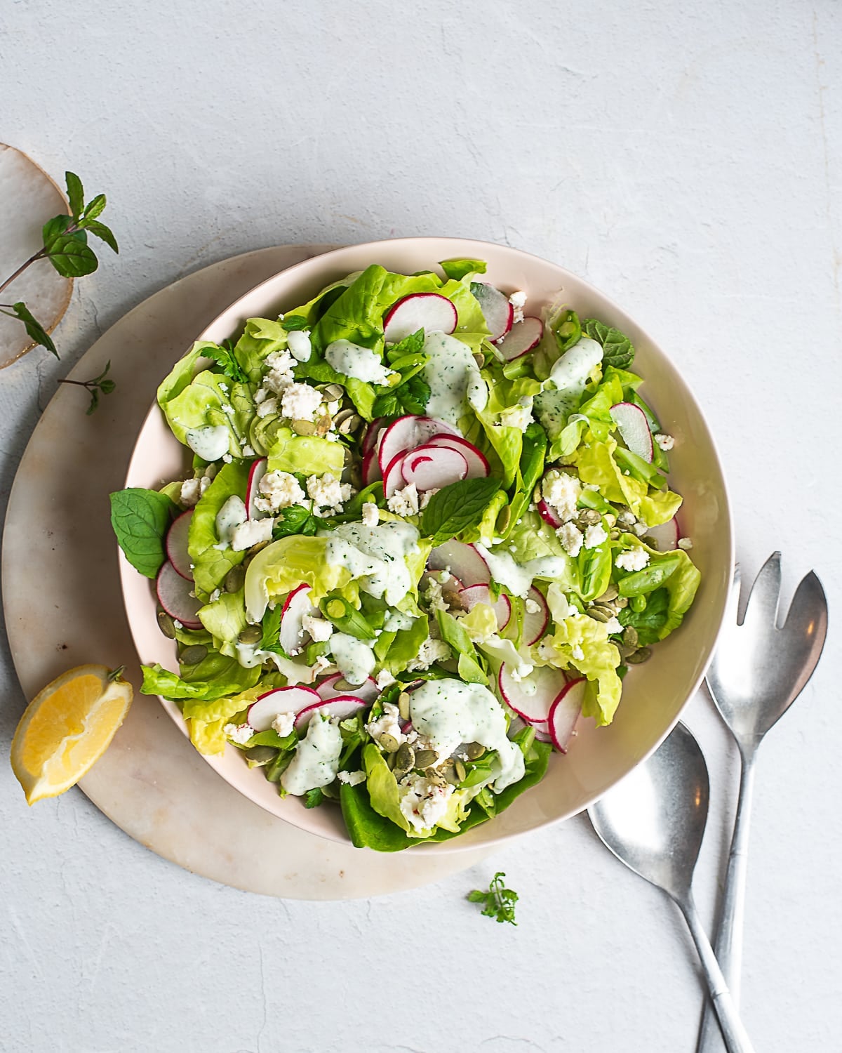 spring salad with lettuce, radishes, snap peas, and creamy herb dressing